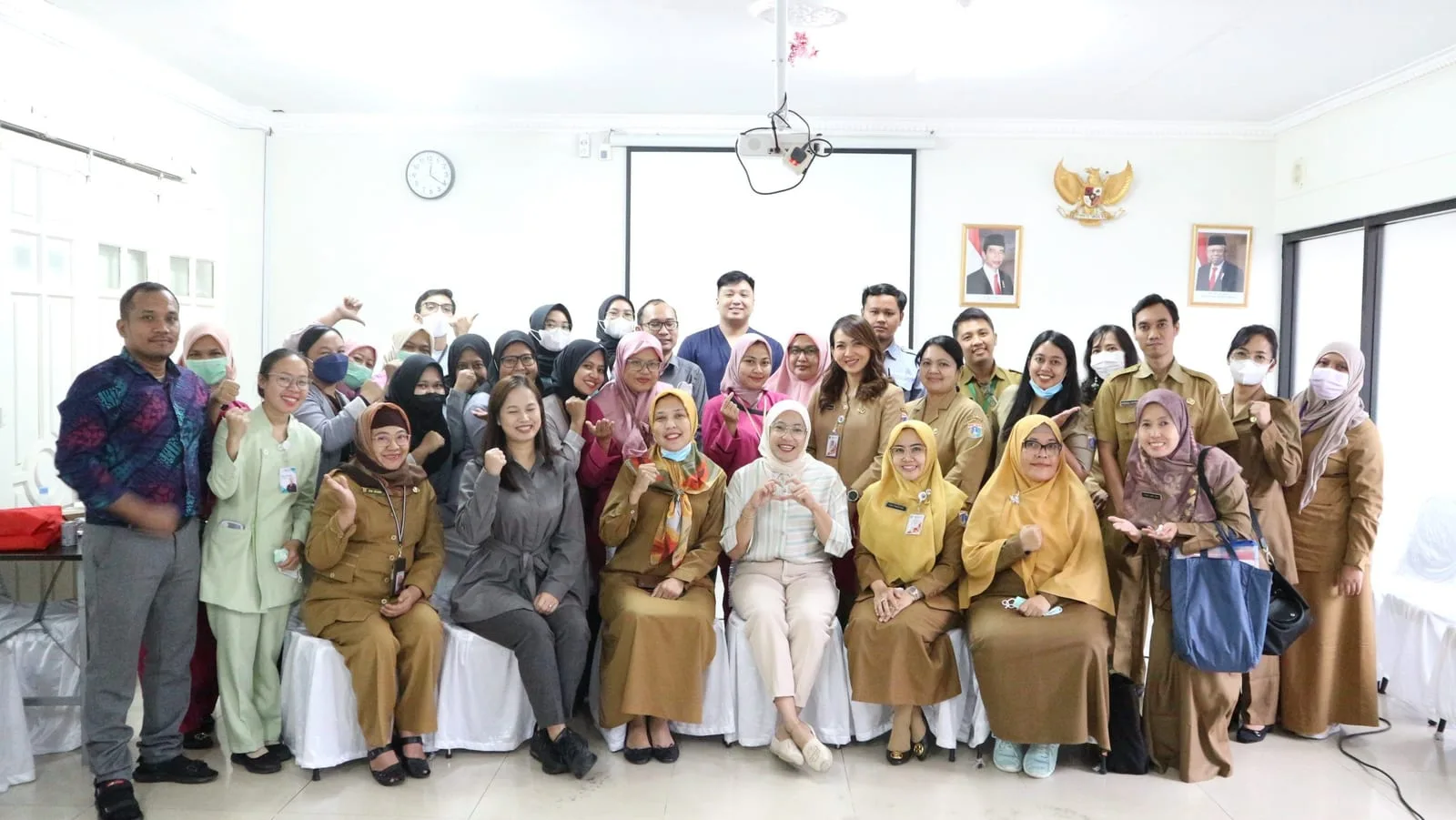 Foto bersama rombongan Suku Dinas Kesehatan Jakarta Barat dan staf RS Anggrek Mas di sebuah ruang pertemuan, sebagian mengenakan seragam dinas berwarna cokelat.
