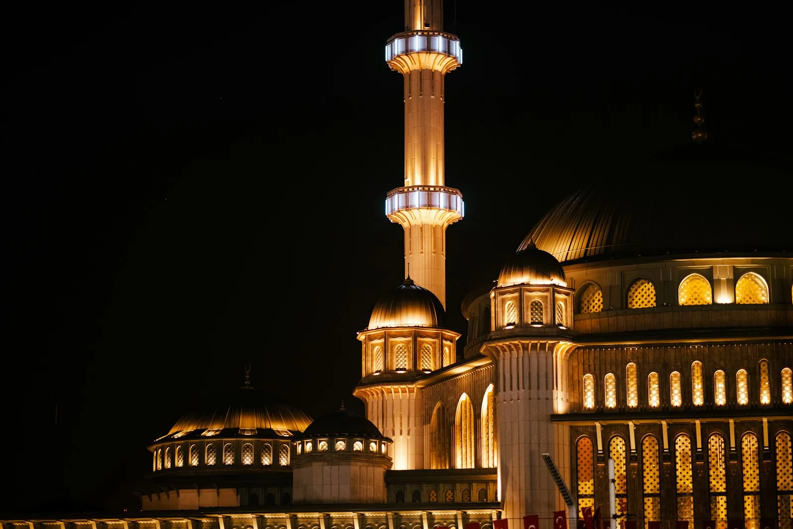 Masjid dengan menara yang diterangi lampu pada malam hari